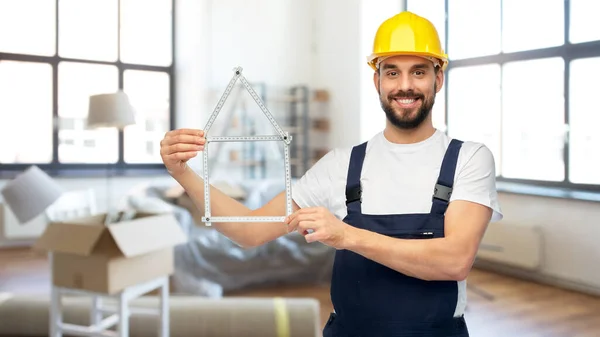 Happy male builder with carpenters rule at home — Stock Photo, Image