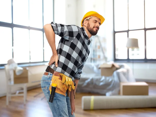 Trabalhador masculino ou construtor com dor nas costas em casa — Fotografia de Stock