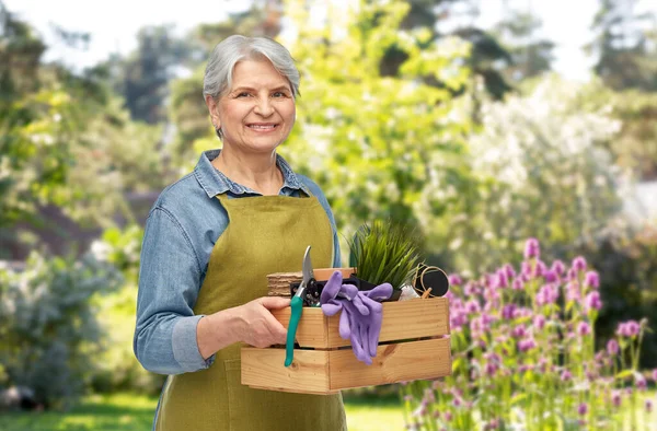 상자 안에 정원 도구를 넣은 할머니의 웃는 모습 — 스톡 사진