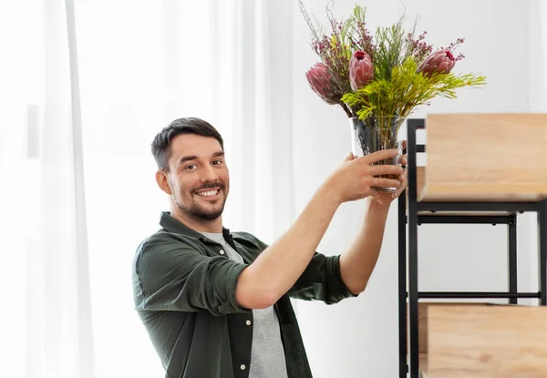 Man versieren huis met bloem of kamerplant — Stockfoto