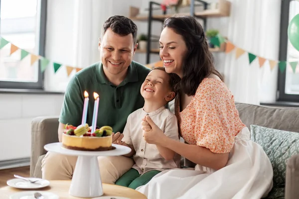 Glückliche Familie mit Geburtstagstorte zu Hause — Stockfoto