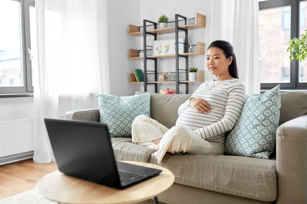 Embarazada asiático mujer con laptop en casa — Foto de Stock