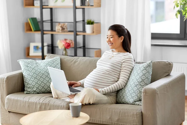 Feliz embarazada asiático mujer con portátil en casa — Foto de Stock