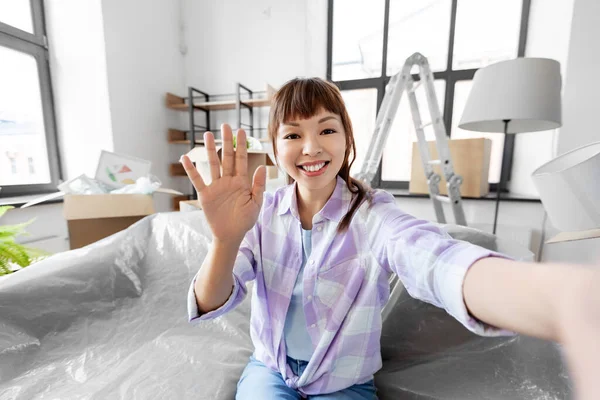 Sonriente asiático mujer tomando selfie en nuevo hogar —  Fotos de Stock