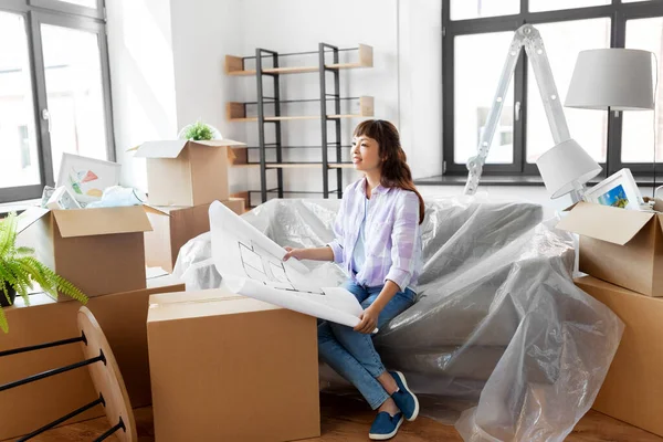 Vrouw met blauwdruk en dozen verhuizen naar nieuw huis — Stockfoto