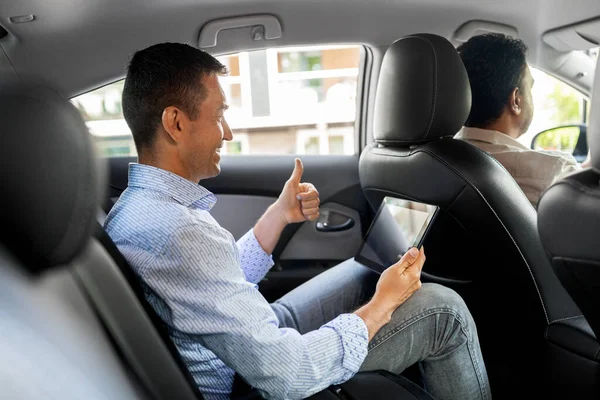 Homme avec tablette PC ayant appel vidéo dans une voiture de taxi — Photo