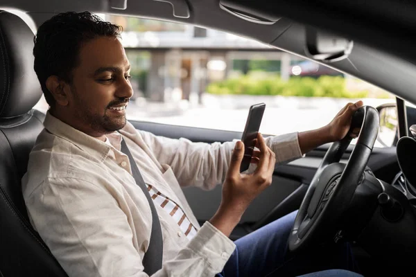 스마트폰을 사용하여 차에서 웃고 있는 인도 남자 — 스톡 사진
