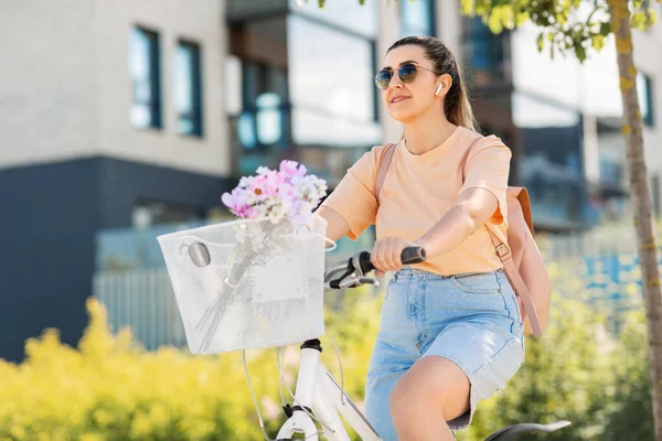 Felice donna con auricolari in bicicletta in città — Foto Stock