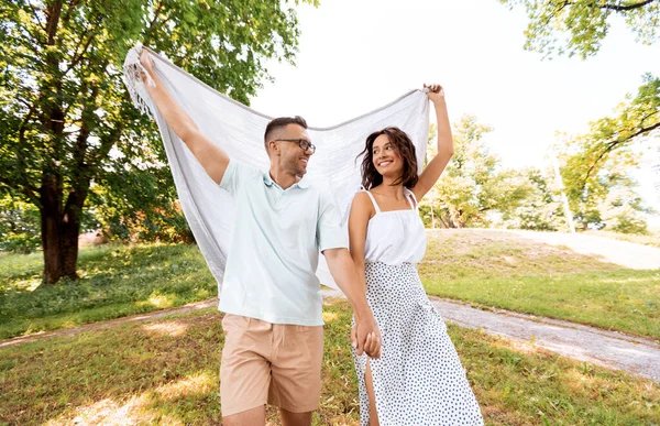 Couple heureux avec couverture de pique-nique au parc d'été — Photo