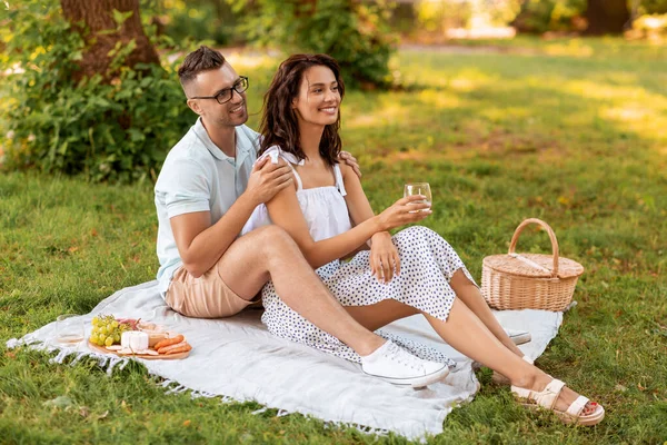 Счастливая пара устраивает пикник в летнем парке — стоковое фото
