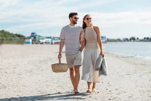 Gelukkig paar met picknickmand wandelen op het strand — Stockfoto