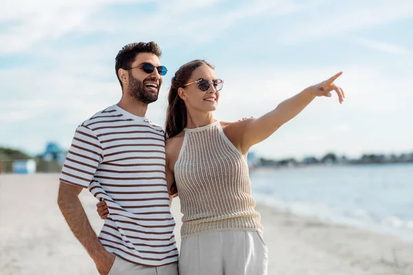 Felice coppia che punta il dito sulla spiaggia estiva — Foto Stock