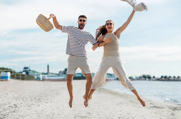 Boldog pár piknik kosár ugrás a strandon Jogdíjmentes Stock Fotók