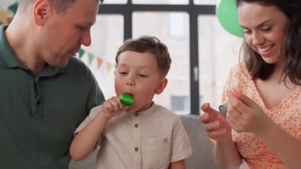 Glückliche Familie mit Party-Blasern, die Spaß zu Hause haben — Stockvideo