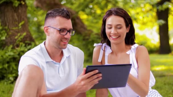 Gelukkig paar met tablet pc in zomerpark — Stockvideo