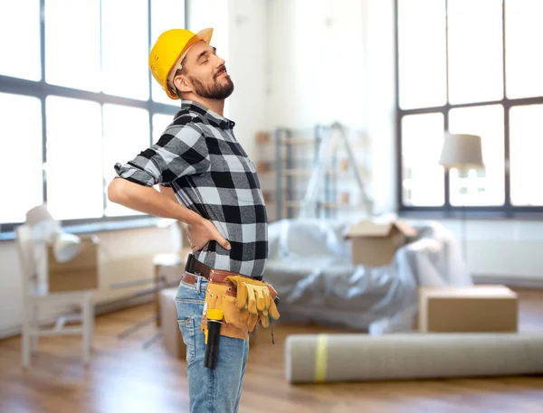 Trabalhador masculino ou construtor com dor nas costas em casa — Fotografia de Stock