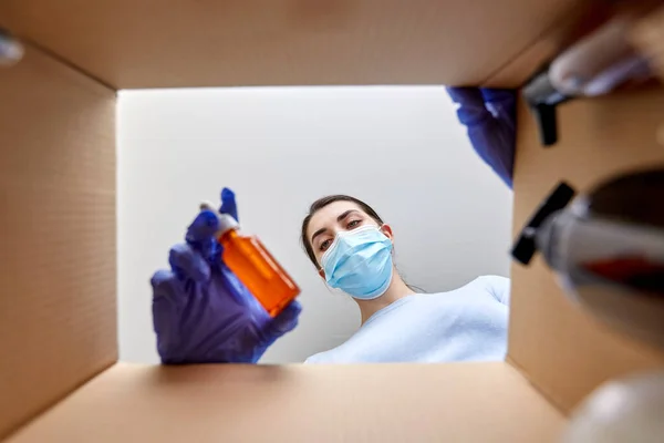 Mulher em máscara desembalagem caixa de pacote com cosméticos — Fotografia de Stock
