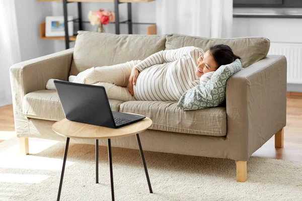 Feliz grávida asiática mulher com laptop em casa — Fotografia de Stock