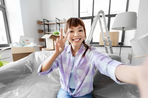 Sonriente asiático mujer tomando selfie en nuevo hogar —  Fotos de Stock