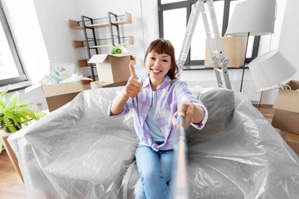 Sonriente asiático mujer tomando selfie en nuevo hogar —  Fotos de Stock