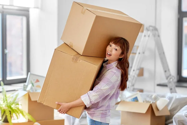 Femme heureuse tenant des boîtes et déménageant dans une nouvelle maison — Photo