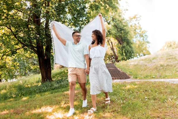 Coppia felice con coperta da picnic al parco estivo — Foto Stock