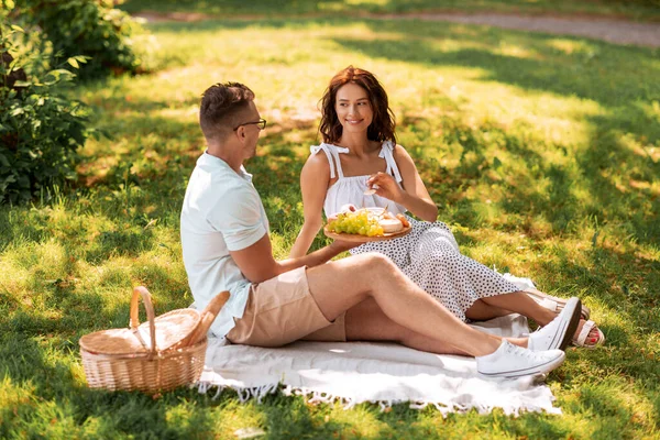 Feliz pareja teniendo un picnic en el parque de verano —  Fotos de Stock