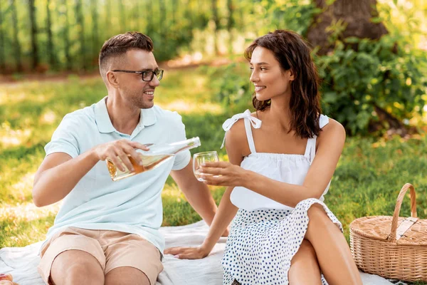 Şaraplı mutlu çift parkta piknik yapıyor. — Stok fotoğraf
