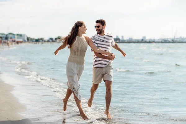 快乐的夫妻在夏天的海滩上奔跑 — 图库照片