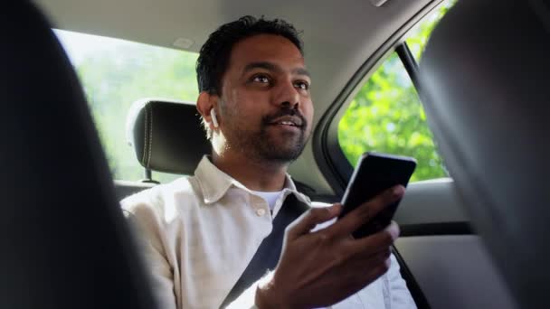 Pasajero indio con auriculares y teléfono en coche — Vídeos de Stock