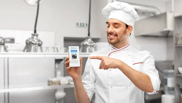 Chef con pasaporte de inmunidad virtual en smartphone —  Fotos de Stock