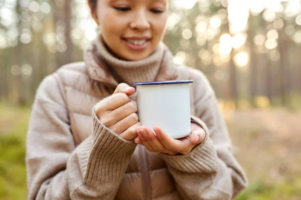 Asiatisk kvinna med mugg dricka te i skogen — Stockfoto