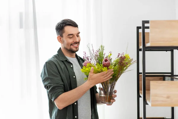 Człowiek dekorowanie domu z kwiatów lub roślin domowych — Zdjęcie stockowe
