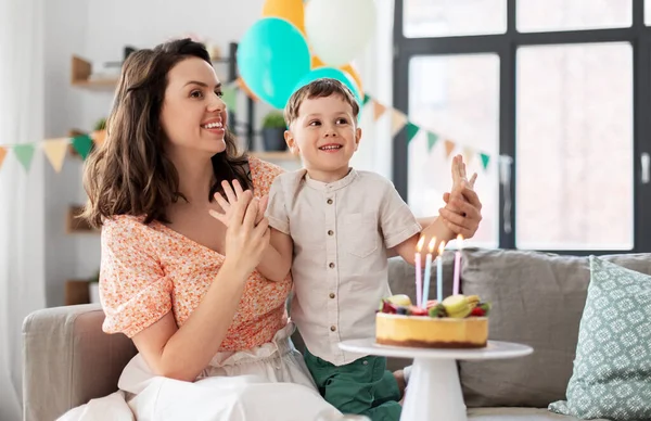 快乐的母亲和儿子带着生日蛋糕在家里 — 图库照片