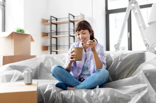 Mujer feliz mudándose a un nuevo hogar y comiendo wok —  Fotos de Stock