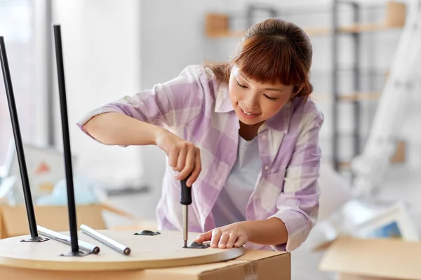 Happy woman assembling coffee table at new home — Stock Photo, Image