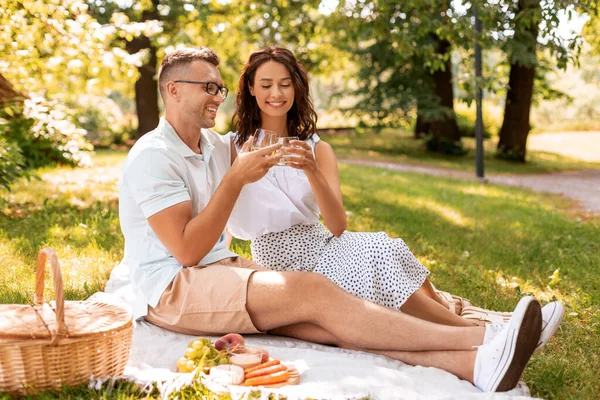 Casal feliz fazendo piquenique no parque de verão — Fotografia de Stock