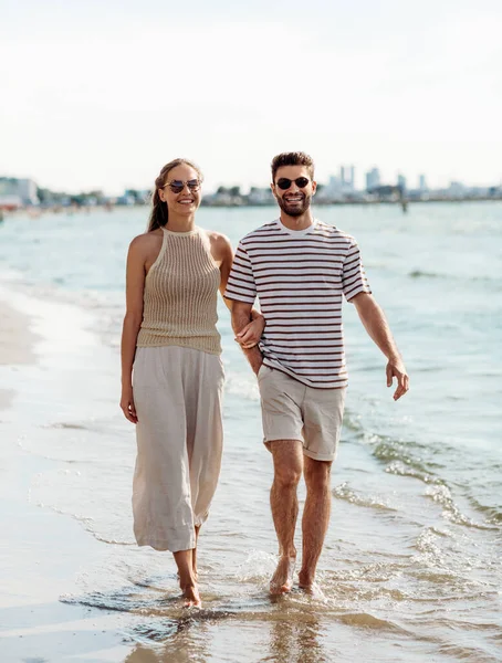 Coppia felice passeggiando lungo la spiaggia estiva — Foto Stock