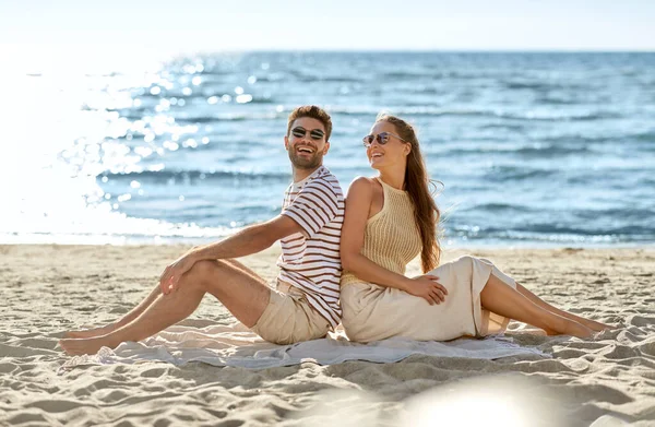 Coppia felice seduta schiena a schiena sulla spiaggia estiva — Foto Stock