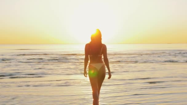 Mujer joven en bikini traje de baño corriendo en la playa — Vídeo de stock