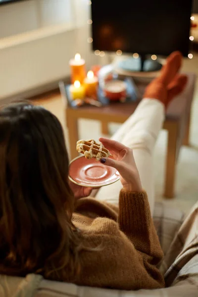 Mujer viendo tv y comiendo waffle en halloween — Foto de Stock