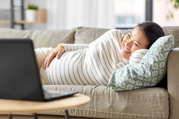 Feliz embarazada asiático mujer con portátil en casa — Foto de Stock
