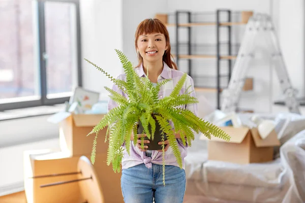 Happy woman with fern flower moving to new home — Stock Photo, Image