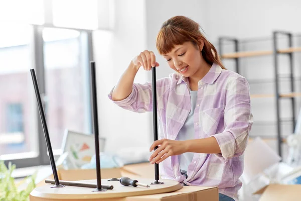 Glückliche Frau baut Couchtisch im neuen Zuhause auf — Stockfoto