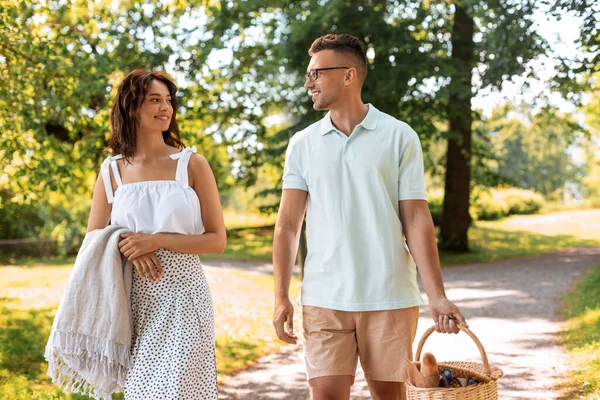 Pareja feliz con cesta de picnic en el parque de verano —  Fotos de Stock