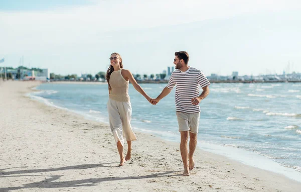Счастливая пара бегает вдоль летнего пляжа — стоковое фото