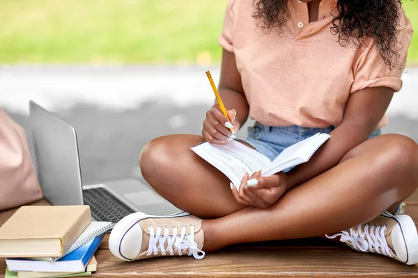 Afrikanska amerikanska student flicka att göra anteckningar i boken — Stockfoto