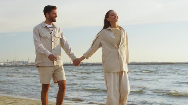Щаслива пара гуляє вздовж літнього пляжу — стокове відео
