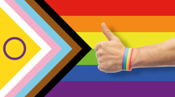 Hand med gay stolthet regnbåge armband visar tumme — Stockfoto