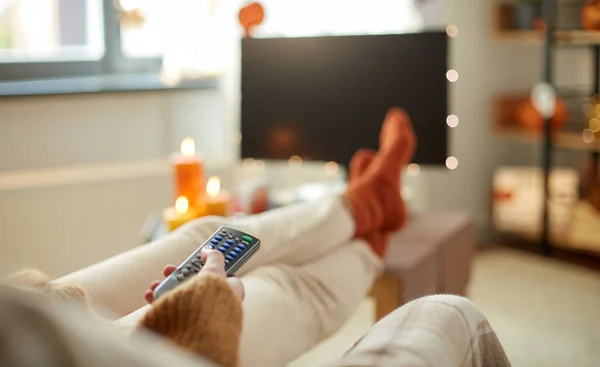 Jonge vrouw kijken tv thuis op halloween — Stockfoto